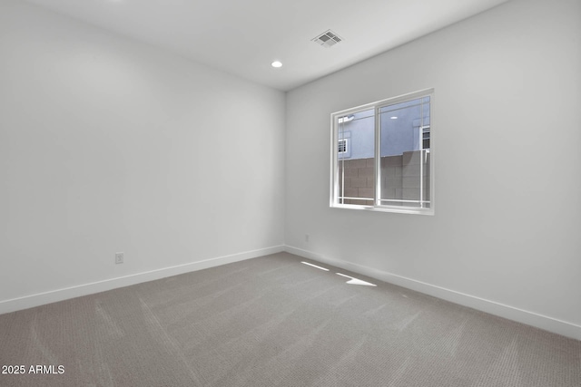 carpeted empty room featuring baseboards, visible vents, and recessed lighting