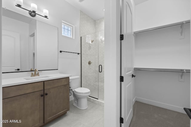 full bathroom featuring a stall shower, vanity, toilet, and a walk in closet