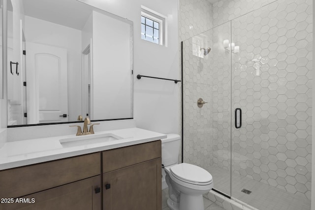 bathroom featuring a stall shower, vanity, and toilet