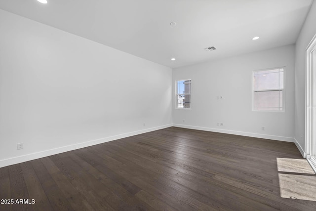 unfurnished room featuring dark wood-style flooring, recessed lighting, visible vents, and baseboards