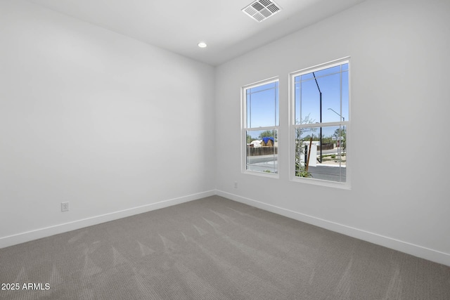 carpeted spare room featuring recessed lighting, visible vents, and baseboards