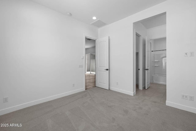 unfurnished bedroom with carpet floors, visible vents, and baseboards