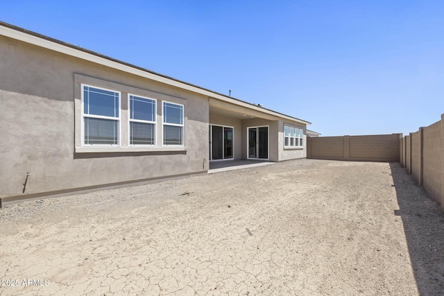 back of property with a fenced backyard and stucco siding