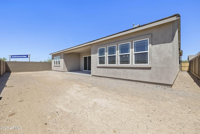 back of house with a patio area, a fenced backyard, and stucco siding