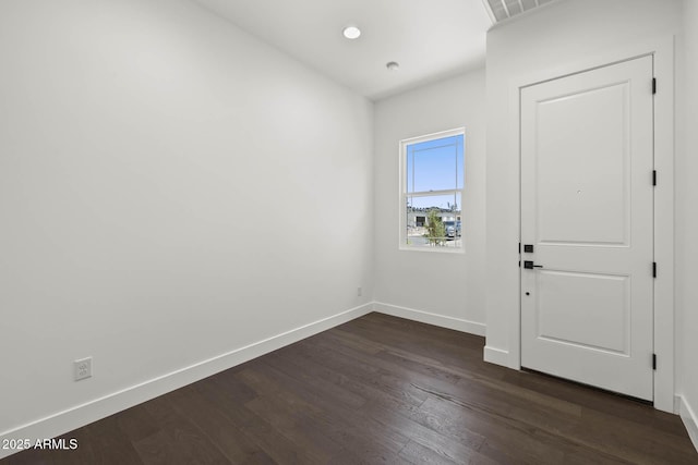 unfurnished room with dark wood-type flooring, recessed lighting, visible vents, and baseboards