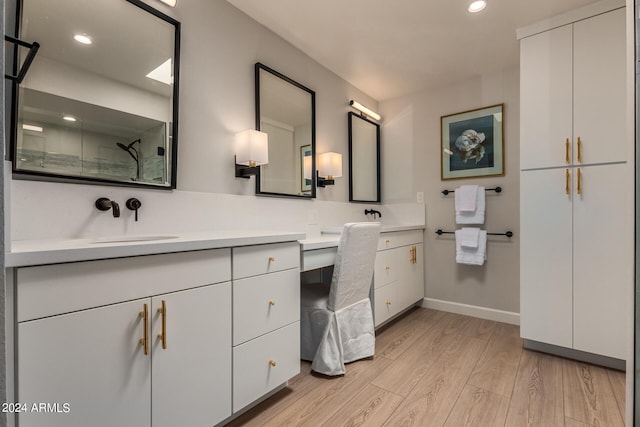 bathroom featuring walk in shower, vanity, and hardwood / wood-style floors