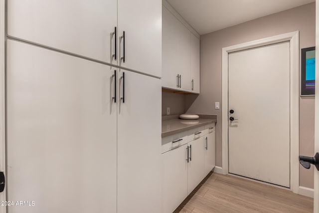 kitchen featuring white cabinets, light hardwood / wood-style flooring, and white fridge