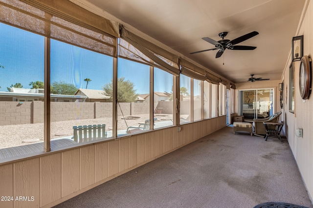 unfurnished sunroom featuring ceiling fan