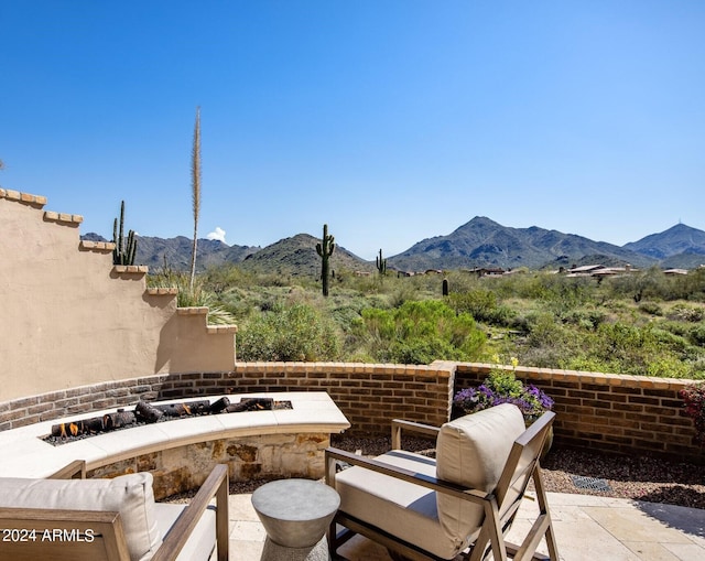 view of patio / terrace with a fire pit and a mountain view