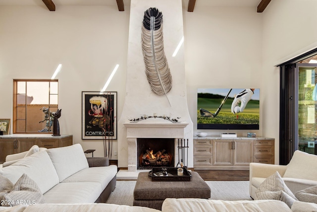 living room with a wealth of natural light, a fireplace, beamed ceiling, and wood-type flooring