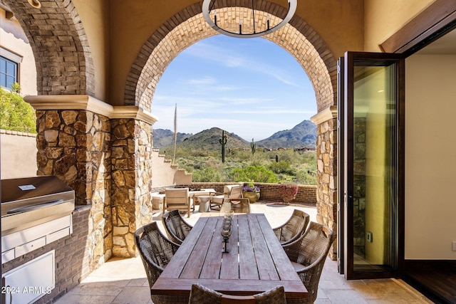 view of patio with area for grilling, a mountain view, and an outdoor kitchen