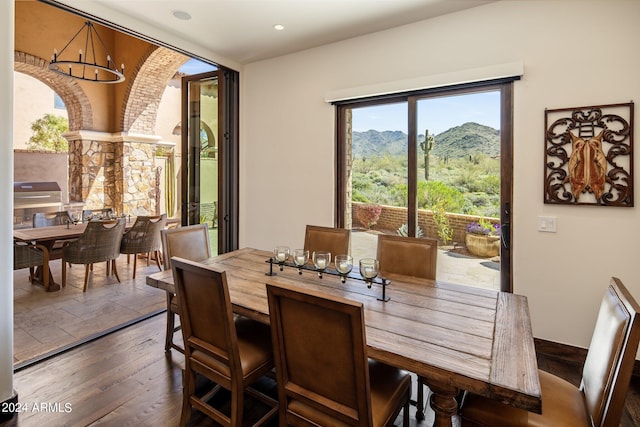 dining space with a mountain view, dark wood-type flooring, and a notable chandelier