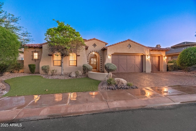 12809 W Oyer Ln, Peoria, AZ 85383 - mediterranean / spanish-style house with a garage, decorative driveway, a tile roof, stucco siding, and a front yard