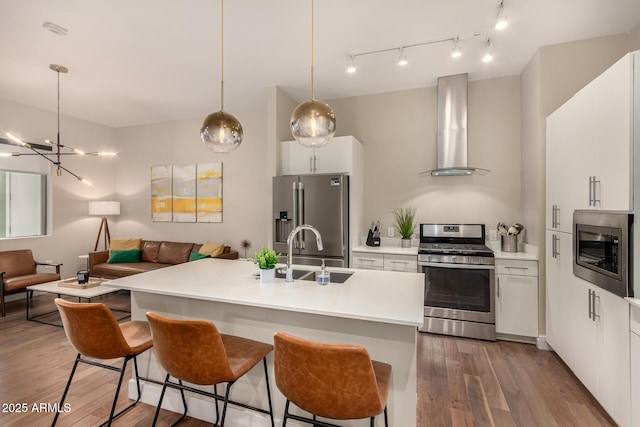 3131 N Central Ave Unit 3004, Phoenix, AZ 85012 - kitchen featuring stainless steel appliances, wall chimney exhaust hood, open floor plan, and wood finished floors