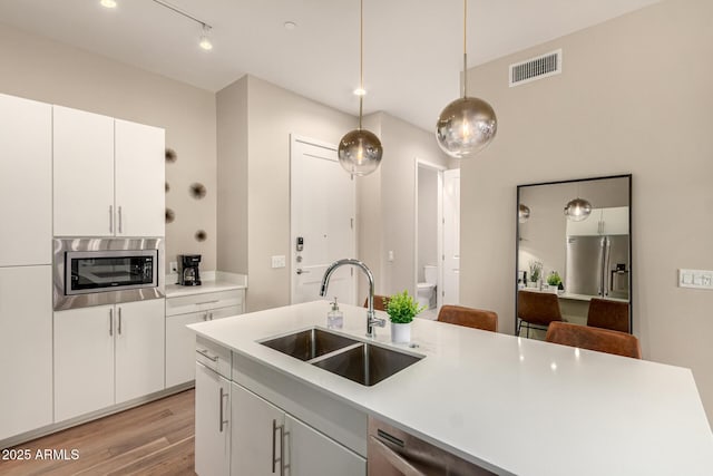 3131 N Central Ave Unit 3004, Phoenix, AZ 85012 - kitchen featuring appliances with stainless steel finishes, light wood-style floors, light countertops, and decorative light fixtures