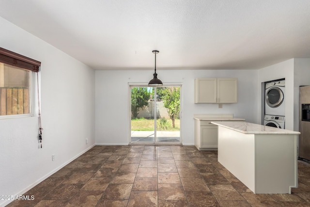 3644 W Maryland Ave, Phoenix, AZ 85019 - kitchen featuring stacked washer / dryer, baseboards, light countertops, stainless steel fridge with ice dispenser, and decorative light fixtures