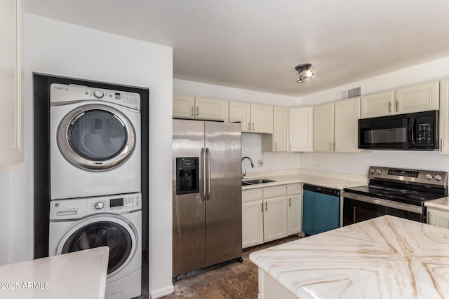 3644 W Maryland Ave, Phoenix, AZ 85019 - kitchen with appliances with stainless steel finishes, stacked washer and clothes dryer, cream cabinetry, a sink, and light countertops