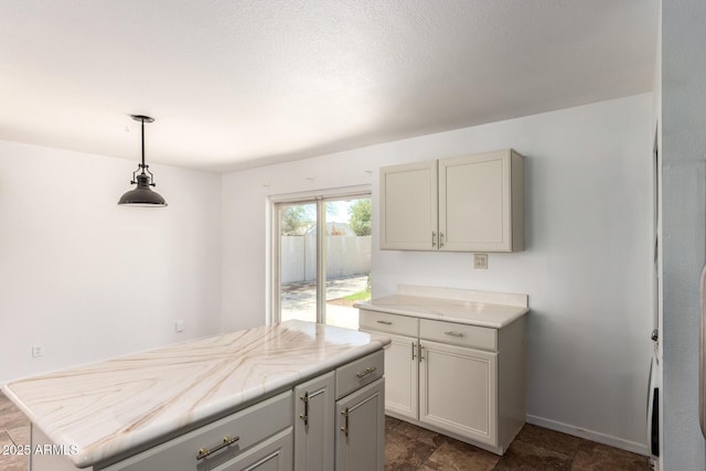 3644 W Maryland Ave, Phoenix, AZ 85019 - kitchen with light countertops, pendant lighting, baseboards, and a center island