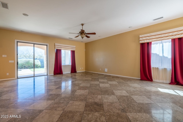 spare room featuring light tile floors and ceiling fan