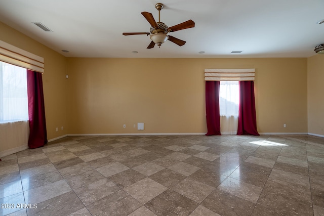 tiled empty room featuring ceiling fan