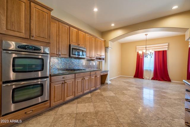 kitchen featuring light tile floors, hanging light fixtures, a chandelier, backsplash, and stainless steel appliances