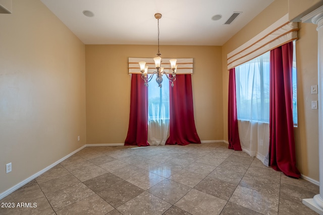 empty room featuring plenty of natural light, an inviting chandelier, and light tile flooring