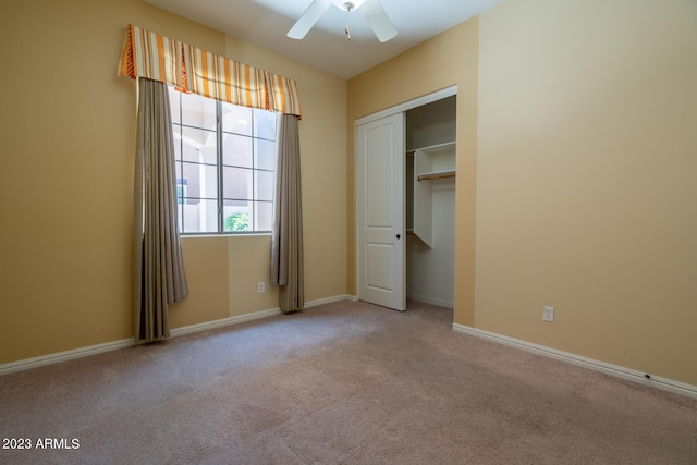 unfurnished bedroom featuring ceiling fan, a closet, and light carpet