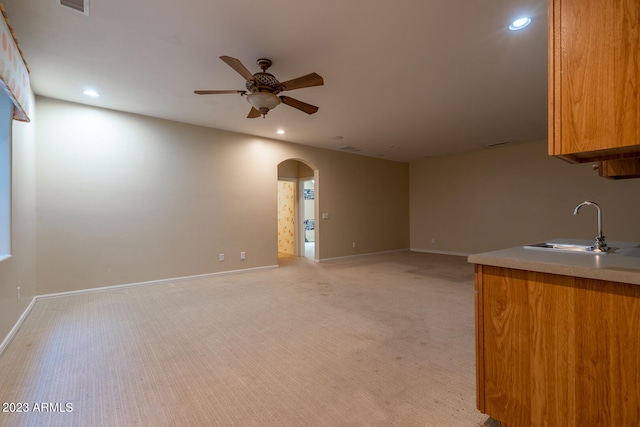 interior space with ceiling fan, sink, and light carpet