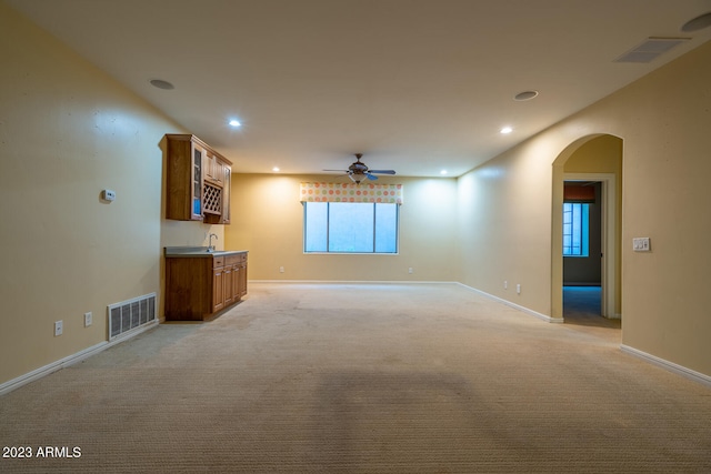 spare room featuring ceiling fan, sink, and light colored carpet