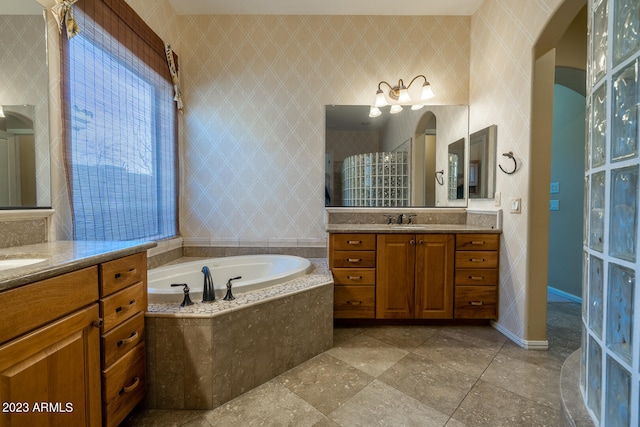 bathroom with a relaxing tiled bath, dual vanity, and tile flooring