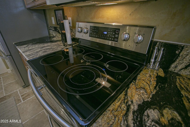 room details with stainless steel electric range oven and dark stone counters