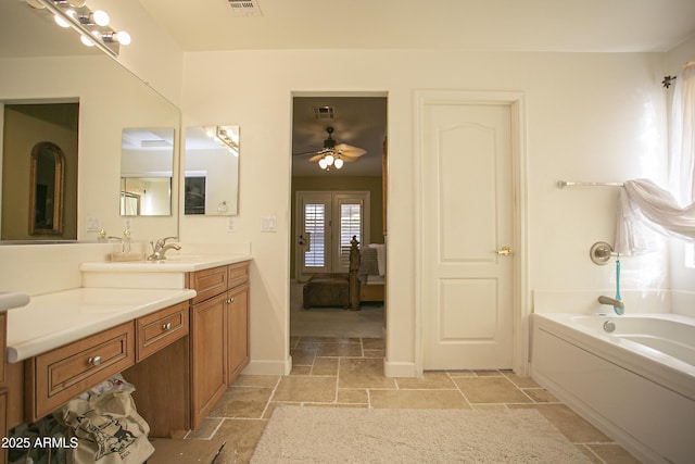 bathroom featuring a bath, ceiling fan, and vanity