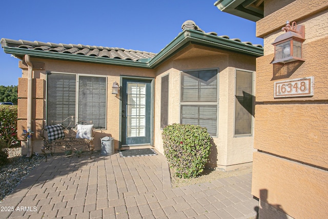 view of exterior entry with a patio