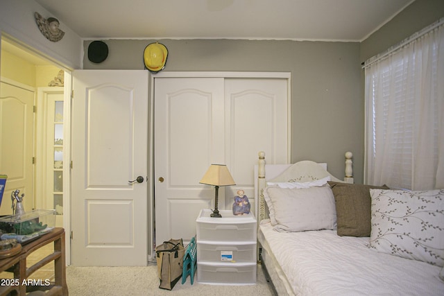 carpeted bedroom featuring a closet and crown molding