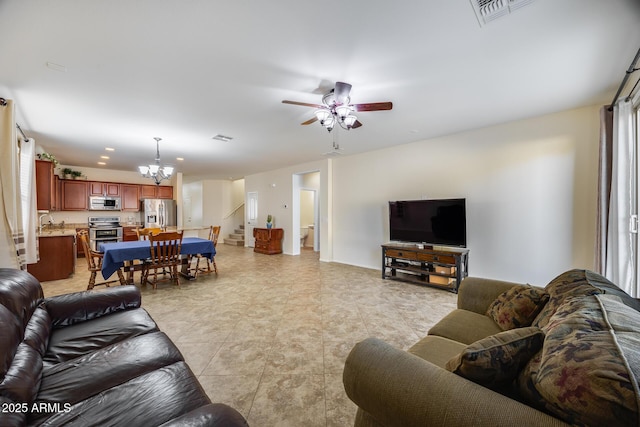 living room featuring ceiling fan with notable chandelier