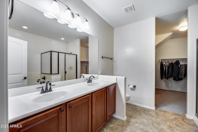 bathroom with vanity, a shower with shower door, tile patterned flooring, and toilet