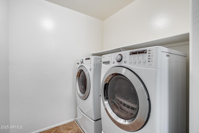 clothes washing area featuring light tile patterned floors and washer and dryer