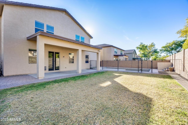 rear view of property with a patio area and a lawn