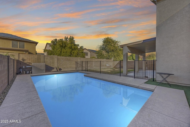 pool at dusk featuring a patio area