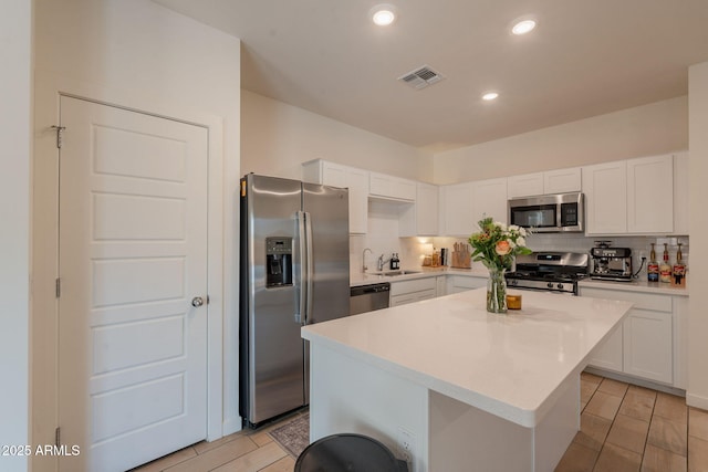 948 E Wiley Way, Casa Grande, AZ 85122 - kitchen with appliances with stainless steel finishes, decorative backsplash, white cabinets, light countertops, and a center island
