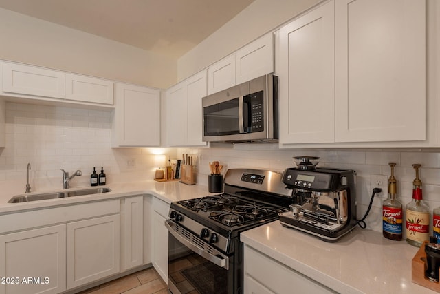 948 E Wiley Way, Casa Grande, AZ 85122 - kitchen featuring stainless steel appliances, a sink, tasteful backsplash, and white cabinetry