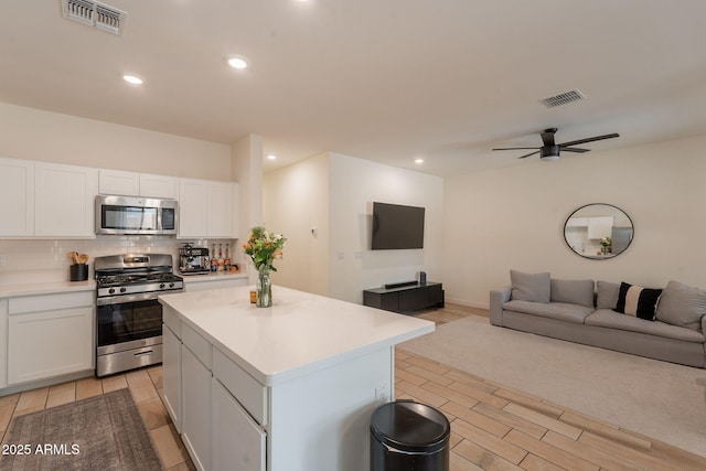 948 E Wiley Way, Casa Grande, AZ 85122 - kitchen with appliances with stainless steel finishes, open floor plan, a kitchen island, white cabinetry, and light countertops