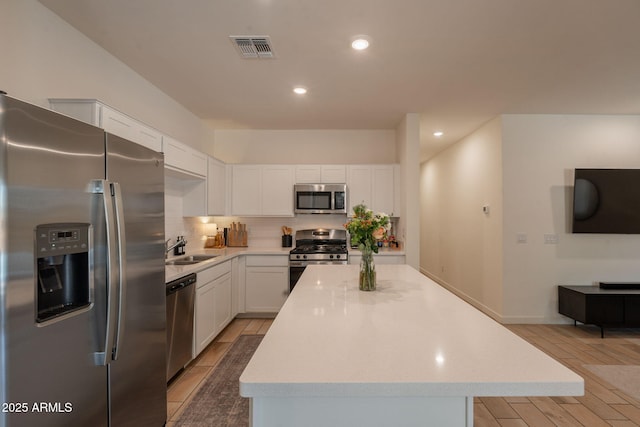 948 E Wiley Way, Casa Grande, AZ 85122 - kitchen featuring stainless steel appliances, a sink, white cabinetry, light wood-style floors, and light countertops