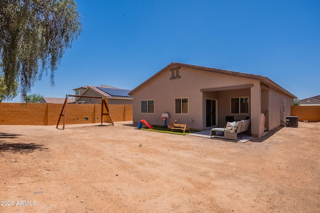 948 E Wiley Way, Casa Grande, AZ 85122 - back of property featuring central AC unit, a fenced backyard, a playground, stucco siding, and a patio area