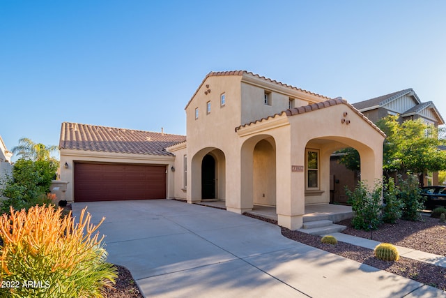 mediterranean / spanish-style house featuring covered porch and a garage