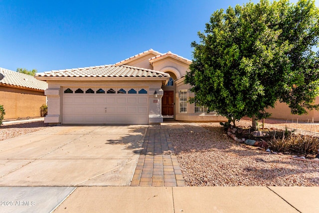 1379 E Butler Cir, Chandler, AZ 85225 - mediterranean / spanish home featuring an attached garage, driveway, a tiled roof, and stucco siding