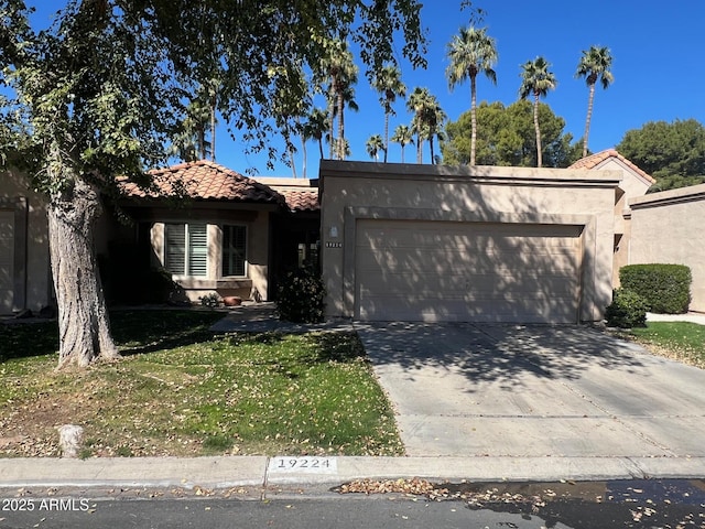 view of front of house with an attached garage, a tiled roof, driveway, stucco siding, and a front lawn