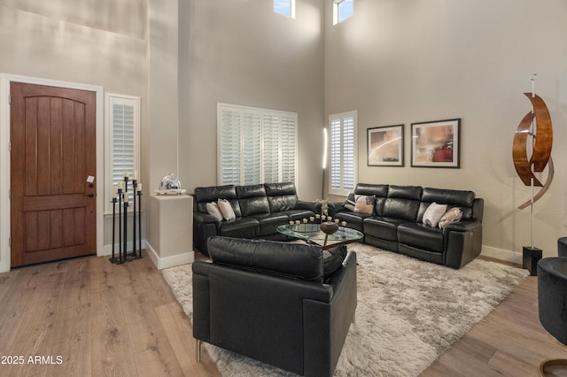 8447 W Tether Trl, Peoria, AZ 85383 - living room featuring light wood-type flooring, a towering ceiling, and plenty of natural light