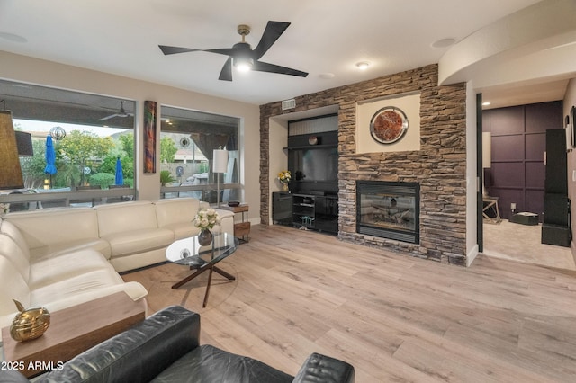 8447 W Tether Trl, Peoria, AZ 85383 - living room featuring a ceiling fan, wood finished floors, and a stone fireplace