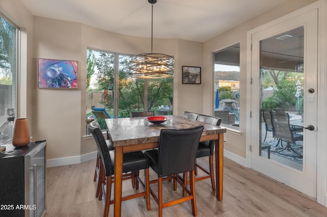 8447 W Tether Trl, Peoria, AZ 85383 - dining space with light wood-type flooring and a chandelier
